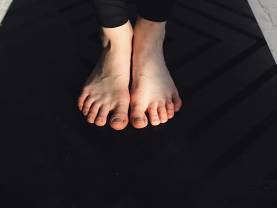 Detail shot of feet on a yoga mat finding balance.