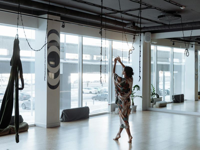 Person in a focused yoga pose in a modern studio.